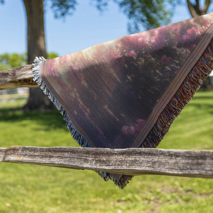 Two Peacocks by Glowing River with Lush Greenery and Vibrant Flowers Under Twilight Light Woven Throw Blanket - Awakening Righteousness
